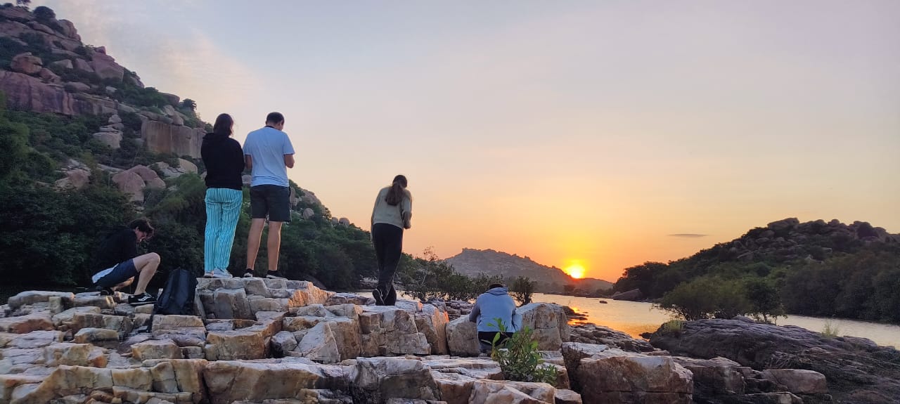 Family in coracle at sunset Sanapur Lake Hampi